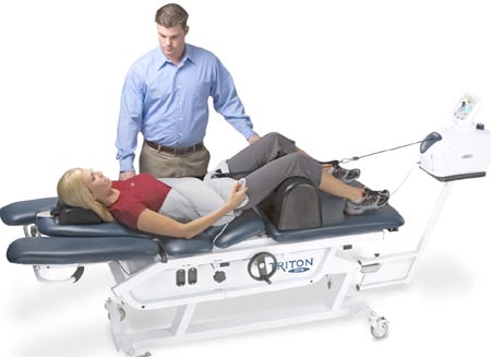 woman lying on a chiropractic bed with a man standing beside her